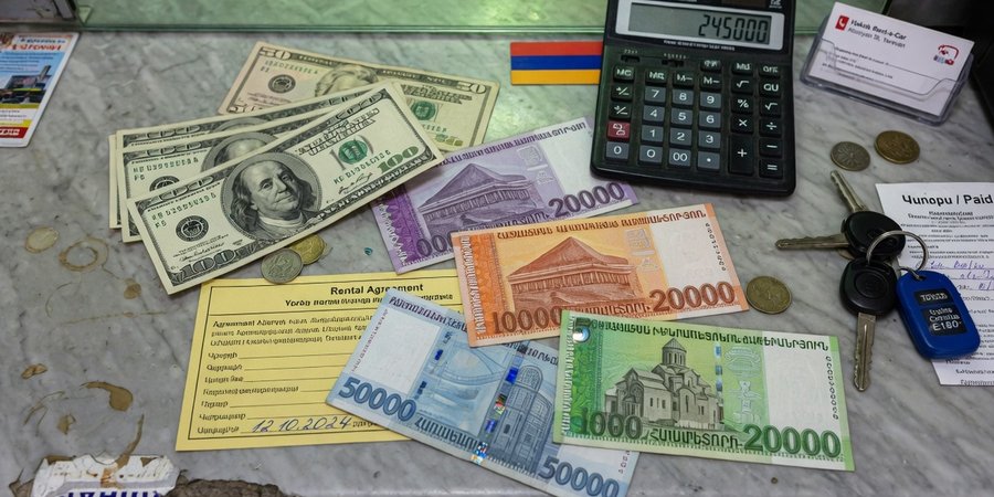 Amerikaanse dollarbiljetten en Armeense dram naast elkaar op een verhuurbalie in Jerevan