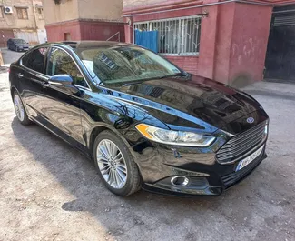 Vooraanzicht van een huurauto Ford Fusion Sedan op de luchthaven van Tbilisi, Georgië ✓ Auto #4184. ✓ Transmissie Automatisch TM ✓ 0 beoordelingen.