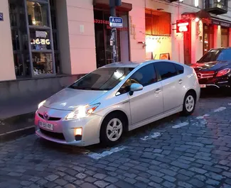 Vooraanzicht van een huurauto Toyota Prius in Tbilisi, Georgië ✓ Auto #4458. ✓ Transmissie Automatisch TM ✓ 1 beoordelingen.