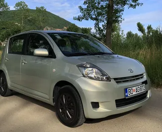 Vooraanzicht van een huurauto Daihatsu Sirion in Budva, Montenegro ✓ Auto #6700. ✓ Transmissie Automatisch TM ✓ 1 beoordelingen.