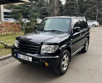 Vooraanzicht van een huurauto Mitsubishi Pajero Io in Tbilisi, Georgië ✓ Auto #6717. ✓ Transmissie Automatisch TM ✓ 1 beoordelingen.