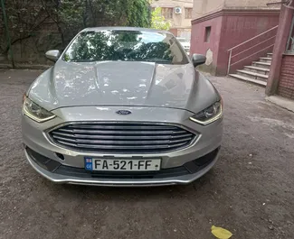 Vooraanzicht van een huurauto Ford Fusion Sedan op de luchthaven van Tbilisi, Georgië ✓ Auto #7129. ✓ Transmissie Automatisch TM ✓ 0 beoordelingen.