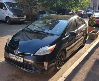 Vooraanzicht van een huurauto Toyota Prius in Tbilisi, Georgië ✓ Auto #7185. ✓ Transmissie Automatisch TM ✓ 2 beoordelingen.