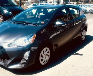 Vooraanzicht van een huurauto Toyota Prius C op de luchthaven van Tbilisi, Georgië ✓ Auto #9558. ✓ Transmissie Automatisch TM ✓ 0 beoordelingen.