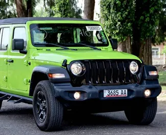 Vooraanzicht van een huurauto Jeep Wrangler Sahara in Tbilisi, Georgië ✓ Auto #10144. ✓ Transmissie Automatisch TM ✓ 0 beoordelingen.