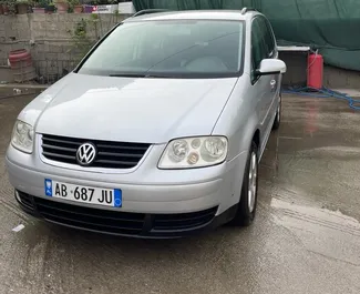 Vooraanzicht van een huurauto Volkswagen Touran op de luchthaven van Tirana, Albanië ✓ Auto #10044. ✓ Transmissie Automatisch TM ✓ 0 beoordelingen.