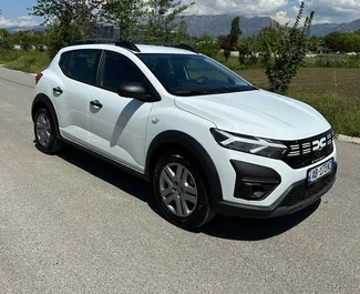 Vooraanzicht van een huurauto Dacia Sandero Stepway op de luchthaven van Tirana, Albanië ✓ Auto #10105. ✓ Transmissie Handmatig TM ✓ 0 beoordelingen.