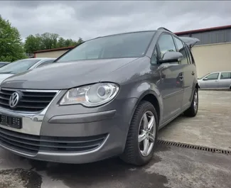 Vooraanzicht van een huurauto Volkswagen Touran op de luchthaven van Tirana, Albanië ✓ Auto #10084. ✓ Transmissie Handmatig TM ✓ 1 beoordelingen.