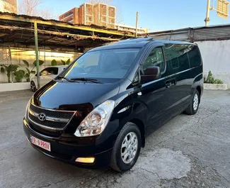 Vooraanzicht van een huurauto Hyundai Grand Starex op de luchthaven van Tirana, Albanië ✓ Auto #11159. ✓ Transmissie Automatisch TM ✓ 0 beoordelingen.