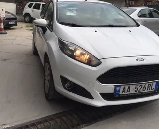 Vooraanzicht van een huurauto Ford Fiesta op de luchthaven van Tirana, Albanië ✓ Auto #11488. ✓ Transmissie Handmatig TM ✓ 0 beoordelingen.