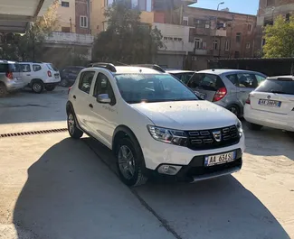 Vooraanzicht van een huurauto Dacia Sandero Stepway op de luchthaven van Tirana, Albanië ✓ Auto #11491. ✓ Transmissie Handmatig TM ✓ 0 beoordelingen.