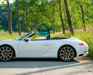 Vooraanzicht van een huurauto Porsche 911 Carrera S Cabrio in Becici, Montenegro ✓ Auto #2480. ✓ Transmissie Automatisch TM ✓ 0 beoordelingen.