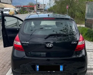 Vooraanzicht van een huurauto Hyundai i20 in Tirana, Albanië ✓ Auto #13090. ✓ Transmissie Handmatig TM ✓ 0 beoordelingen.