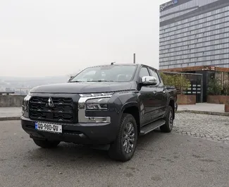 Vooraanzicht van een huurauto Mitsubishi L200 in Tbilisi, Georgië ✓ Auto #13654. ✓ Transmissie Automatisch TM ✓ 0 beoordelingen.