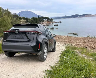 Vooraanzicht van een huurauto Toyota Yaris Cross op Podgorica Luchthaven, Montenegro ✓ Auto #15687. ✓ Transmissie Automatisch TM ✓ 0 beoordelingen.