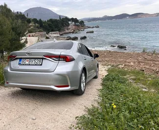 Vooraanzicht van een huurauto Toyota Corolla Sedan op Podgorica Luchthaven, Montenegro ✓ Auto #16204. ✓ Transmissie Automatisch TM ✓ 0 beoordelingen.